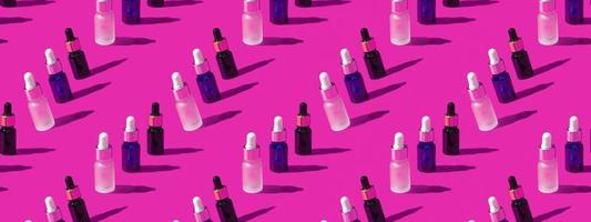 Cosmetic bottle mockup with cosmetics on pink background with hard shadows, closeup copy space photo