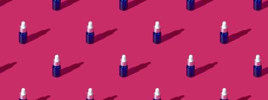 Cosmetic bottle mockup with cosmetics on pink background with hard shadows, copy space closeup. pattern photo