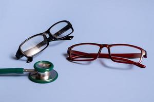 Classic glasses and a stethoscope on a blue background. Medical concept. Closeup with copy space photo