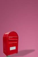 Cover page with big fancy red metal postbox with white empty note space for address isolated at pink gradient background with copy space. Concept of communication and post service. photo