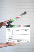 holding Movie clapper board against white wall photo