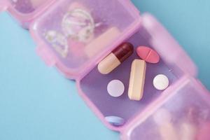 top view of medical pills in a pill box on color background photo