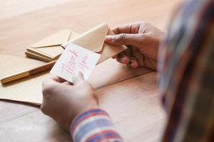 close up of man hand reading a thank you letter photo