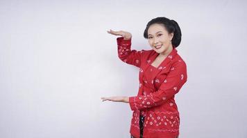 Asian beauty in kebaya pointing blank side isolated on white background photo