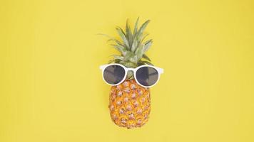 pineapple in glasses isolated on a yellow background photo