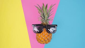 Pineapple with glasses on a colorful background photo