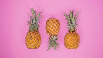 a few pineapples isolated on a pink background photo