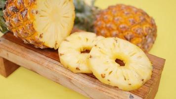 pineapple fruit and several round pieces isolated on a yellow background photo