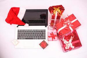 laptop and gitf box for christmas and new year celebration isolated on white background photo