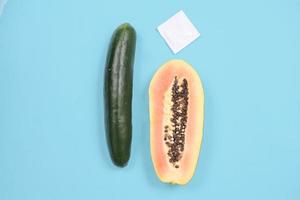 sex education with cucumber and contraception isolated on blue background photo