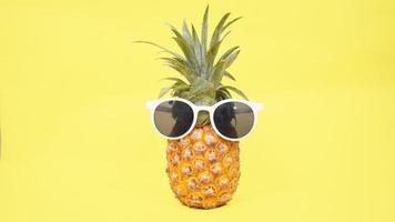 pineapple in glasses isolated on a yellow background photo