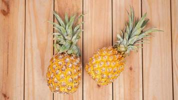 two pineapples on a wooden background photo