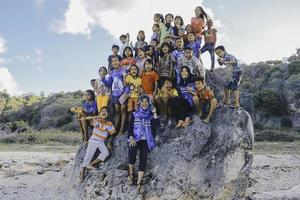 Nusa Tenggara Oriental, Indonesia, los niños animan juntos y disfrutan jugando en la gran roca de la playa. ntt rote, indonesia - abril de 2020. foto