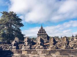 muchas estatuas budistas con fondo de candi plaosan o templo plaosan en el complejo templo plaosan. uno de los templos budistas javaneses ubicado en prambanan, klaten, java central, indonesia. foto