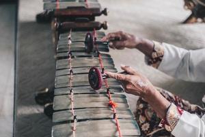 A man Hand use batik playing gamelan Gender or Slenthem. photo