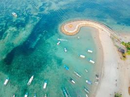 vista aérea de drones del océano, barcos, playa, costa en la playa de sanur, bali, indonesia con barcos de pesca tradicionales balineses increíble océano azul. foto