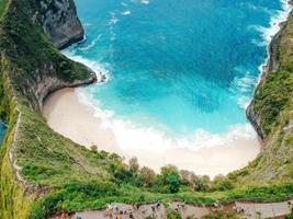 Aerial drone view of blue ocean view of seashore at Manta Bay or at Kelingking Beach on Nusa Penida Island, Bali, Indonesia photo