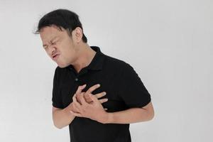 Heart attack or broken heart of young asian man with hurt emotion wear black shirt photo