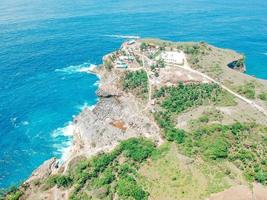 Aerial drone top view of coral beach and blue ocean waves In Nusa Penida, Bali, Indonesia. Overhead View Of Rocky Coast And Coves photo