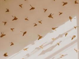pájaro origami en fondo de pared blanca foto