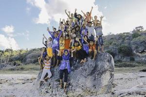 East Nusa Tenggara Indonesia Kids are cheering together enjoy playing in the big rock on the beach. NTT ROTE, INDONESIA - April, 2020. photo