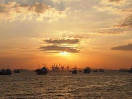 Cargo ship and cranes at port harbour in Tanjung Perak Surabaya with sunset sky background. photo