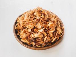 Pile of Onion fries or shallots with spread in several sides on wood plate isolated on white background. photo