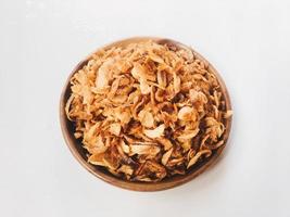 Pile of Onion fries or shallots with spread in several sides on wood plate isolated on white background. photo