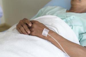 Close up of visitor holding senior patient's hand in hospital, health care and medical concept photo