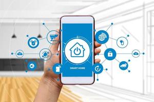 Hand of woman or man holding smartphone in house with icons in modern life internet of things, smart home technology. concept of automation. the new innovation of the future in living room photo