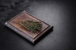 Bundle of fresh thyme grass on a wooden cutting board photo