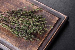 manojo de hierba de tomillo fresco en una tabla de cortar de madera foto