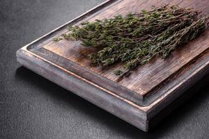 Bundle of fresh thyme grass on a wooden cutting board photo