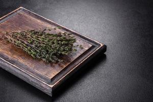 manojo de hierba de tomillo fresco en una tabla de cortar de madera foto