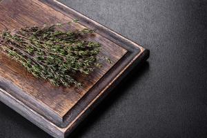 Bundle of fresh thyme grass on a wooden cutting board photo