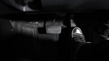 Accelerate and Brake. Foot pressing foot pedal of a car to drive ahead. photo