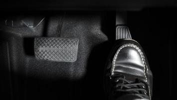 Accelerate and Brake. Foot pressing foot pedal of a car to drive ahead. photo