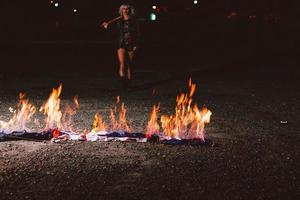 Portrait of stylish blonde grunge young woman  with the club near the fire at night photo