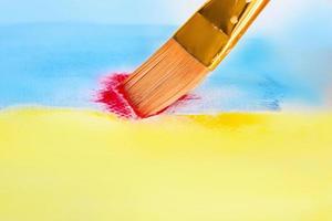 Brush with blue and yellow and red paint watercolor photo