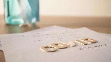 Covid insurance form with blurred alcohol bottle. Papers on the table. photo