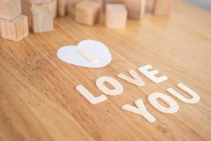 These words mean I LOVE U in wood plates. The square blocks use for background elements. Valentine's day concept. photo