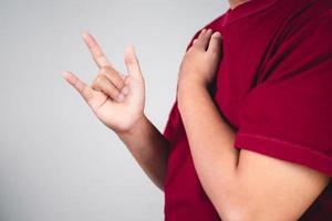 signo de amor propio. abrazarte a ti mismo y pensar en positivo. el hombre con camisa roja en primer plano medio. copiar espacio para mensajes, palabras y textos. foto