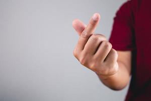 Finger heart in korean style. Sign of love isolated on white and grey background. Valentine's day concept. photo