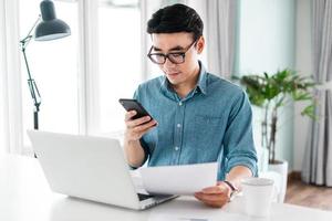 portrait of asian man sitting working from home photo