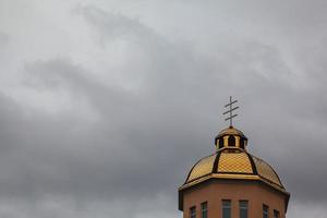 Golden domes orthodox church with cross against blue sky photo