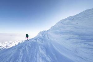 una mujer camina con raquetas de nieve en las montañas, trekking de invierno foto