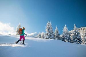 A woman walks in snowshoes in winter trekking photo