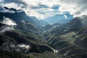 Scenery of Tram Ton Pass or O Quy Ho Pass is mountain pass winding in valley with foggy at Sapa, Northwest Vietnam photo