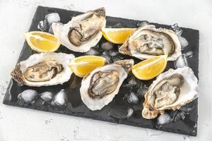 Raw oysters on the slate board photo