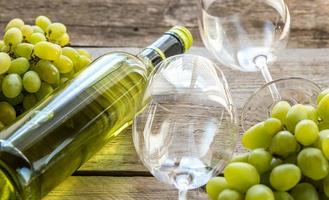 Bottle of white wine with bunch of grape photo